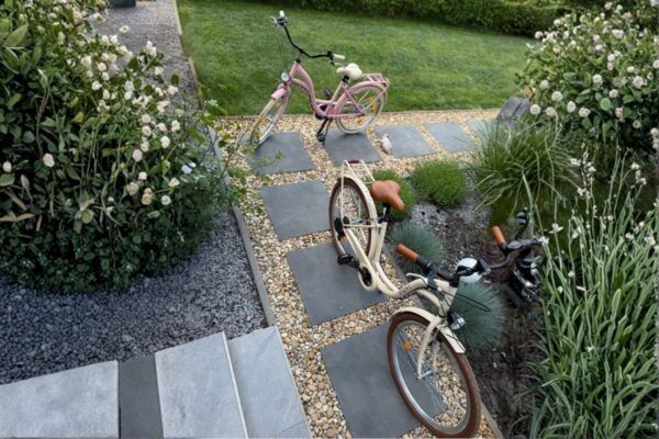 Kaksi polkupyörää puutarhapolulla.